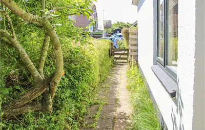 a small alley way next to a white building at 'T Zilt in Bergen aan Zee