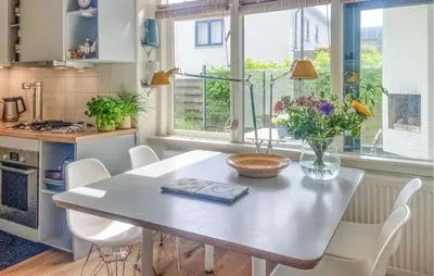 a kitchen with a table and chairs with flowers on it at 'T Zilt in Bergen aan Zee