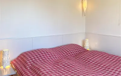 a bed with a red checkered blanket on it at 'T Zilt in Bergen aan Zee