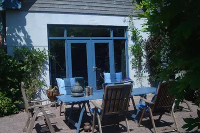 a blue table and chairs in front of a house at Vakantiewoning De Lotus in Hoevelaken