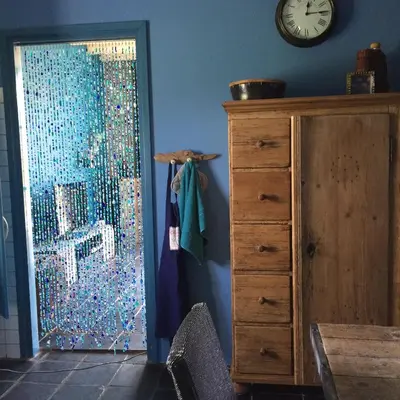 a room with a sliding glass door with a dresser and a clock at Vakantiewoning De Lotus in Hoevelaken