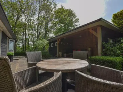 a patio with a table and chairs and a building at De IJsvogel in Heiloo