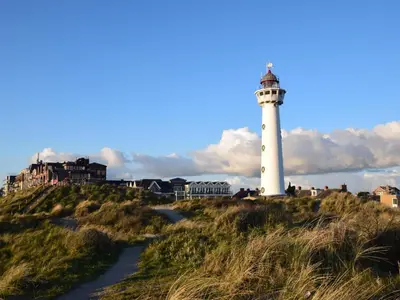 a lighthouse sitting on top of a grassy hill at De IJsvogel in Heiloo