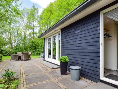 a patio outside of a house with chairs and windows at De IJsvogel in Heiloo