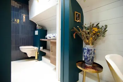 a bathroom with a vase with flowers on a table at Najade Eco Houseboat in Amsterdam