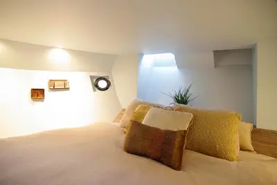 a bedroom with a bed with a clock on the wall at Najade Eco Houseboat in Amsterdam
