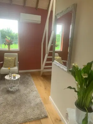 a living room with a mirror and a stairway at Het Dijkje Utrecht in Utrecht