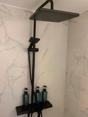 a shower shelf with three bottles on it in a bathroom at Het Dijkje Utrecht in Utrecht