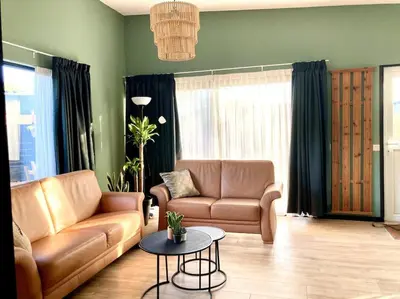 a living room with a couch and a table at Holiday home Beachy Days near ocean & lake in Noordwijkerhout