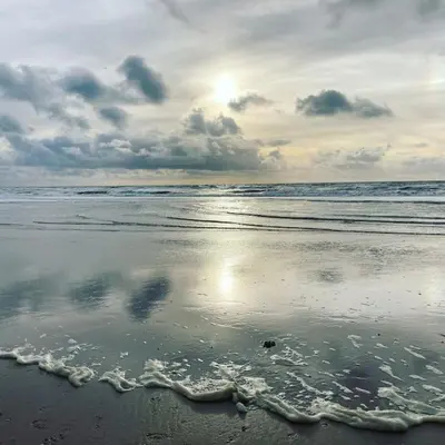 a beach with the sun reflecting on the wet sand at Holiday home Beachy Days near ocean & lake in Noordwijkerhout