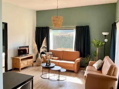 a living room with a couch and a table at Holiday home Beachy Days near ocean & lake in Noordwijkerhout