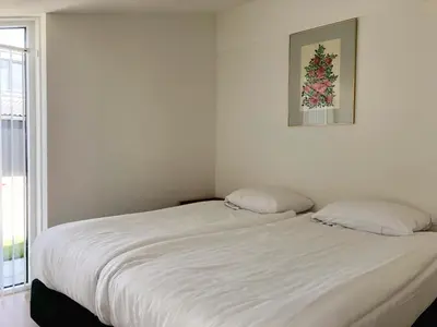 a white bed with two pillows in a bedroom at Bungalow 74 op Recreatiepark De Wielen in Sint Maarten