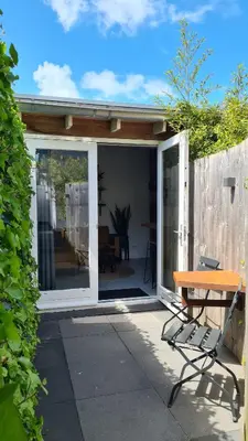 a sliding glass door on a patio with a bench at Koninginnehuis 35 in Zandvoort