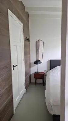a bedroom with a bed and a mirror on the wall at Koninginnehuis 35 in Zandvoort
