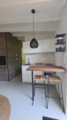 a kitchen with a wooden table and a pendant light at Koninginnehuis 35 in Zandvoort