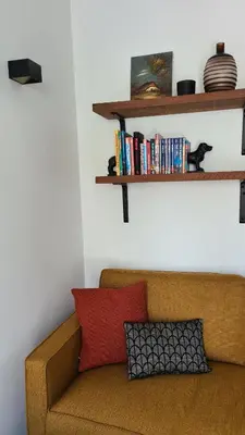 a brown couch sitting in a living room with shelves at Koninginnehuis 35 in Zandvoort