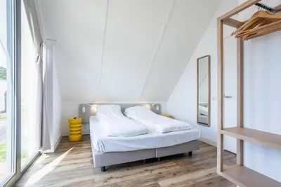 a bedroom with a bed and a mirror at Duyndomein Noordwijk in Noordwijk