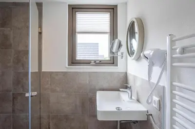 a bathroom with a sink and a mirror at Duyndomein Noordwijk in Noordwijk