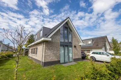 a house with a car parked in a yard at Duyndomein Noordwijk in Noordwijk