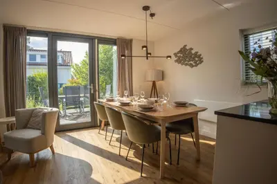 a dining room with a wooden table and chairs at Duyndomein Noordwijk in Noordwijk