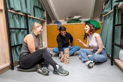 three people sitting on the floor in a room at The Bee Hostel in Amsterdam