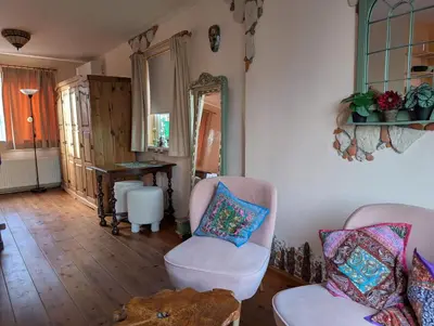 a living room with two chairs and a mirror at La Cabaña in Zandvoort