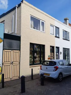 a car parked in front of a building with a garage at La Cabaña in Zandvoort