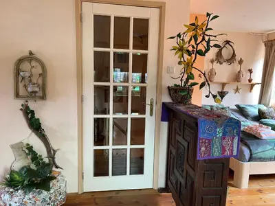 a room with a bed and a cabinet with a window at La Cabaña in Zandvoort