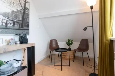 a small kitchen with two chairs and a table at Raam Studio's in Amsterdam