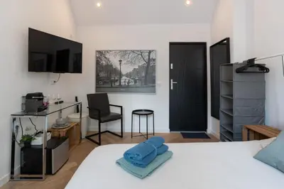 a bedroom with a bed and a desk and a chair at Raam Studio's in Amsterdam