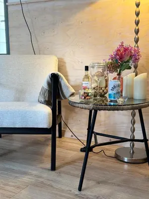a table and a chair and a table with flowers and bottles at Studio 41 Bergen NH in Bergen