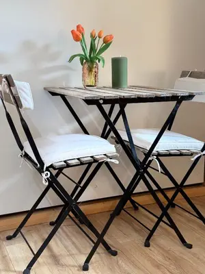 a table with two chairs and a vase with flowers at Studio 41 Bergen NH in Bergen