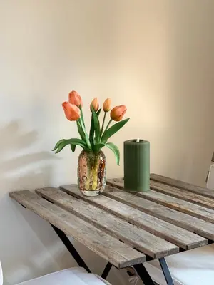 a vase with orange flowers sitting on a wooden table at Studio 41 Bergen NH in Bergen