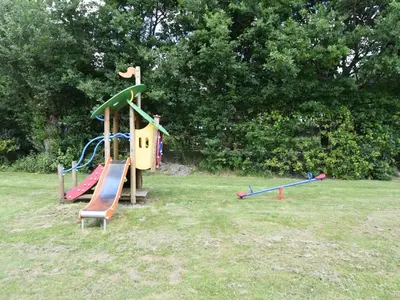 a playground with a slide in a park at Holiday Home in Flevoland with Pool in Zeewolde
