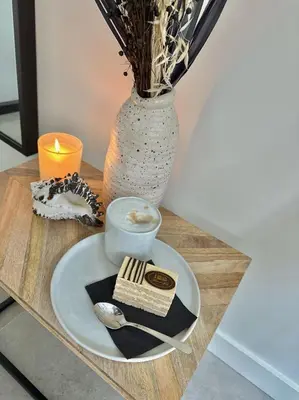 a table with a plate of food and a vase at The Lighthouse Cabin in Noordwijk