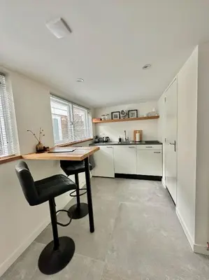 a kitchen with a desk and a chair in a room at The Lighthouse Cabin in Noordwijk