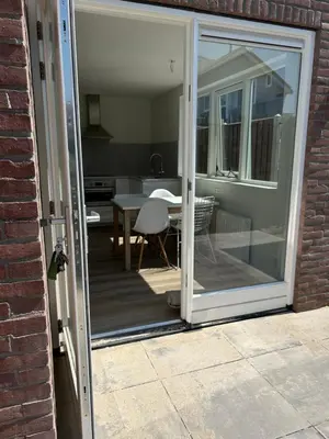 a sliding glass door leading to a patio with a table at Have a nice stay! - Paris Plage - volledig vernieuwd, free parking in Noordwijk aan Zee