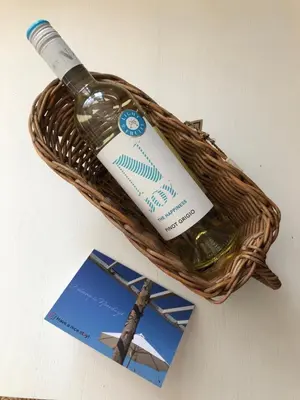 a bottle of wine in a basket next to a card at Have a nice stay! - Paris Plage - volledig vernieuwd, free parking in Noordwijk aan Zee