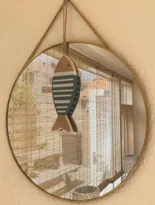 a mirror hanging on a wall with a bird cage at Have a nice stay! - Paris Plage - volledig vernieuwd, free parking in Noordwijk aan Zee
