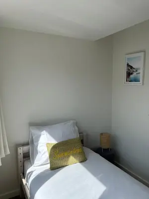 a bed with a yellow pillow on top of it at Have a nice stay! - Paris Plage - volledig vernieuwd, free parking in Noordwijk aan Zee