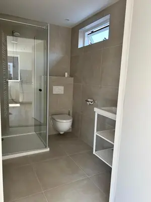 a bathroom with a toilet and a glass shower at Have a nice stay! - Paris Plage - volledig vernieuwd, free parking in Noordwijk aan Zee