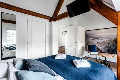 a bedroom with a blue bed and a tv at 't Duinpannetje in Zandvoort