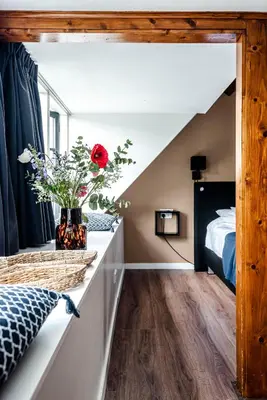 a bedroom with a bed and a vase of flowers on a counter at 't Duinpannetje in Zandvoort