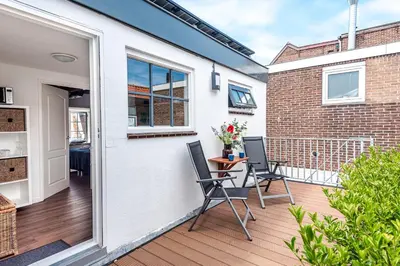 a patio with two chairs and a table on a balcony at 't Duinpannetje in Zandvoort