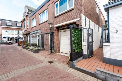 a brick building with a white door on a street at 't Duinpannetje in Zandvoort