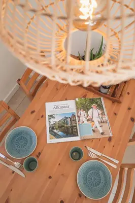 a table with plates and a book on it at Kelp in Egmond aan Zee