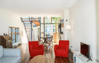 a living room with red chairs and a staircase at Nice Home In Breukeleveen With Wifi in Breukeleveen