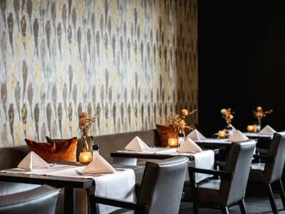 a row of tables in a restaurant with candles on them at Van der Valk Hotel Hoorn in Hoorn