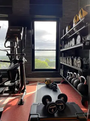 a room with a gym with weights and a window at Van der Valk Hotel Hoorn in Hoorn
