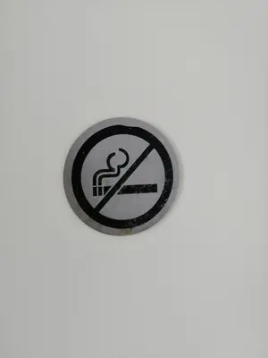 a button with a no smoking sign on a white wall at All you need, a comfy place in Amsterdam